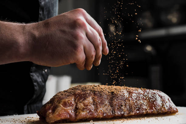 Tips para cocinar carne, una persona agregando finas yerbas a un corte de carne